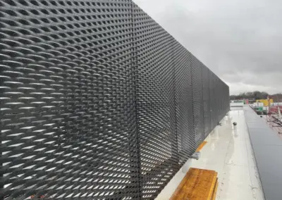 Streckmetallfassaden als schwarze Fassadenbekleidung mit definierter Maschenrichtung und Luftdurchlass am Dachrand