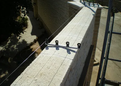 Climb-over protection with electric fence on the wall of a factory in Spain