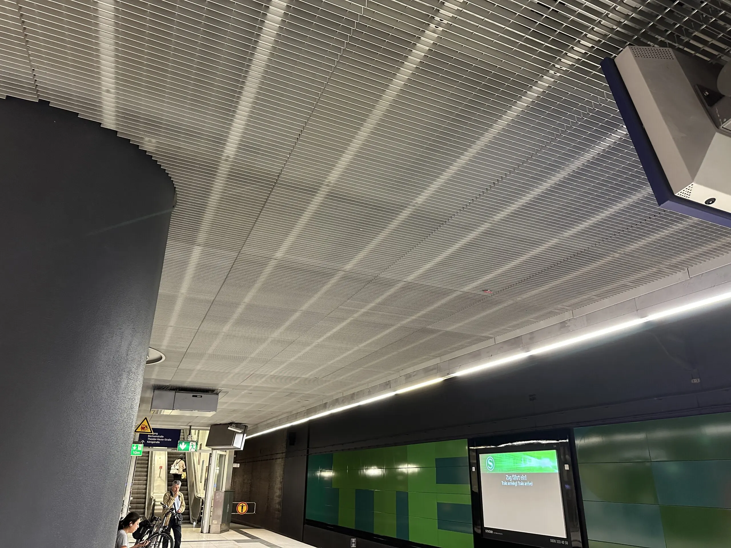 Aluminium-Gitterrostdecke über einem Stuttgarter S-Bahnsteig mit integrierter Beleuchtung und darunter hängenden Anzeigen