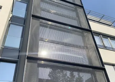 Außenverkleidung eines Aufzugsschachts aus Streckmetall mit gerasterten Paneelen und ruhiger Optik