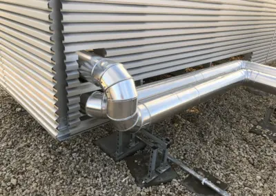 Integration technischer Leitungen hinter einer Lamellenwand auf einem Flachdach